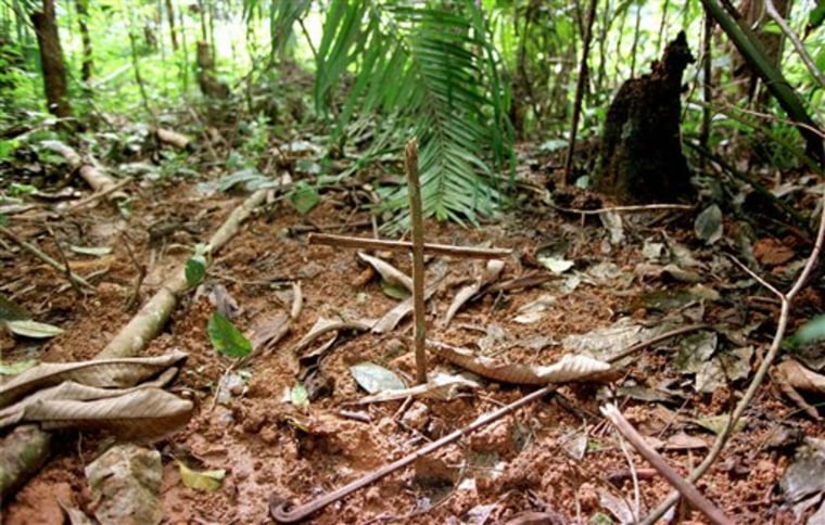 A cross marks graves in eastern Congo that were photographed in 1997. A Tutsi soldier, who asked not to be identified, alleged Rwandan Hutu refugees were secretly buried here after being beaten, hacked or shot to death by rebel alliance soldiers. 